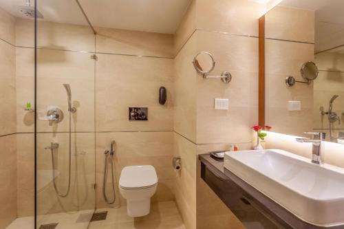 a bathroom with a shower and a toilet and a sink at Residency Tower in Trivandrum