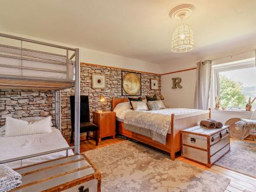 een slaapkamer met 2 bedden en een stenen muur bij 3 Bed in Pitlochry 59677 in Pitlochry