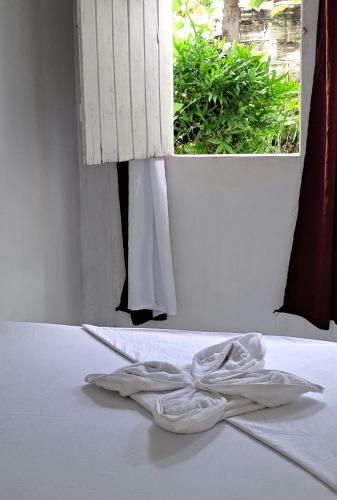 a pair of towels sitting on a bed in front of a window at Estresse Zero in Atins
