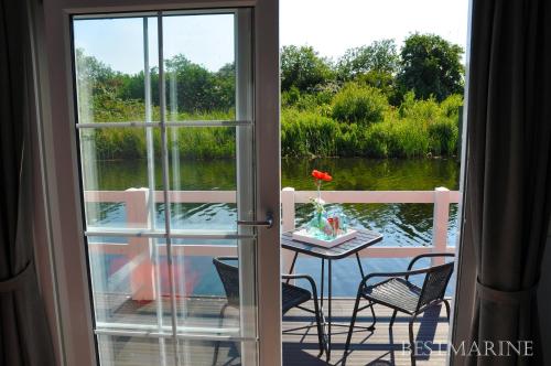 a balcony with a table and a view of the water at BestMarine Waterchalets Flevo Marina in Lelystad