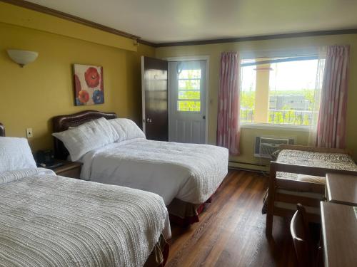 ein Hotelzimmer mit 2 Betten und einem Fenster in der Unterkunft Hotel Motel Le Château in Lac-Mégantic