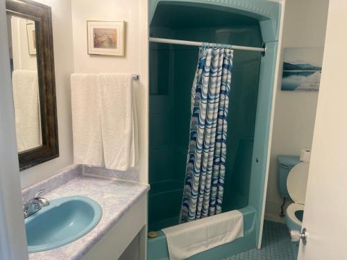 a bathroom with a sink and a shower at Hotel Motel Le Château in Lac-Mégantic