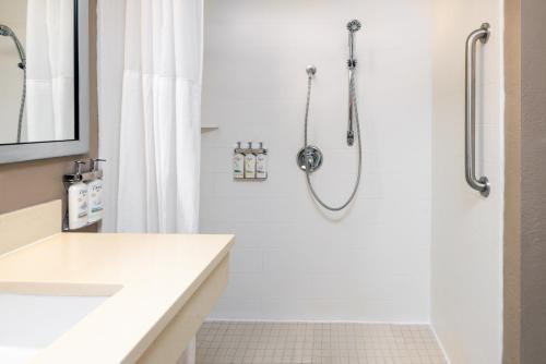 a white bathroom with a shower and a sink at Holiday Inn Miami-Doral Area, an IHG Hotel in Miami