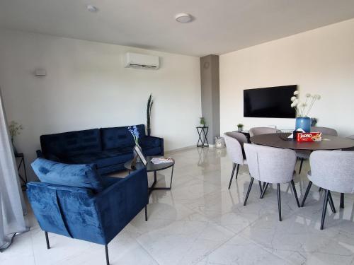 uma sala de estar com um sofá azul e uma mesa em Deluxe Apartment Mila em Nin