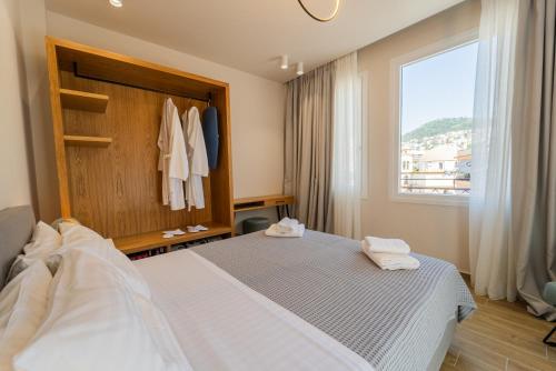 a bedroom with a white bed and a window at Iridium Old Town Luxury Suites in Kavala