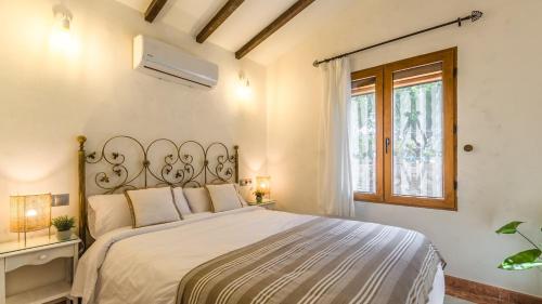 een slaapkamer met een bed en een raam bij Casa La Mimosa Velez-Malaga by Ruralidays in Vélez-Málaga