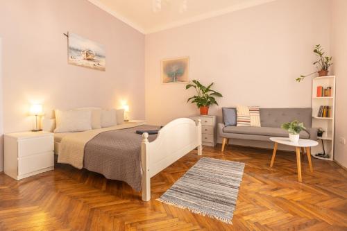 ein Schlafzimmer mit einem Bett und einem Sofa in der Unterkunft Gellerico Rooms at Horánszky Street in Budapest