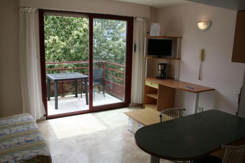 - un salon avec vue sur un balcon doté d'une table dans l'établissement Studio + piscine+ parking privé. Quartier Minimes, à La Rochelle