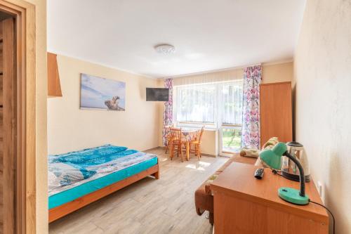 a bedroom with a bed and a desk and a table at Pokoje gościnne Żaczek in Dębki