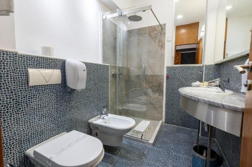 y baño con aseo, ducha y lavamanos. en Hotel Astra, en Sarajevo