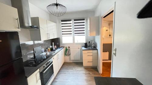 une cuisine avec des armoires blanches et des appareils noirs dans l'établissement Michel Perrot, à Concarneau