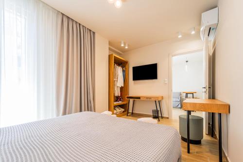 a bedroom with a bed and a desk and a window at Iridium Old Town Luxury Suites in Kavala