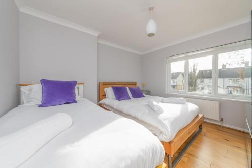 2 camas en una habitación con almohadas moradas en Holbrook house, en Cambridge