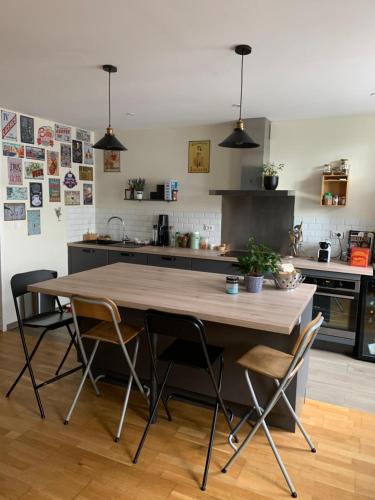 une cuisine avec une table et des chaises en bois dans l'établissement Maison de charme en sologne, à Ligny-le-Ribault