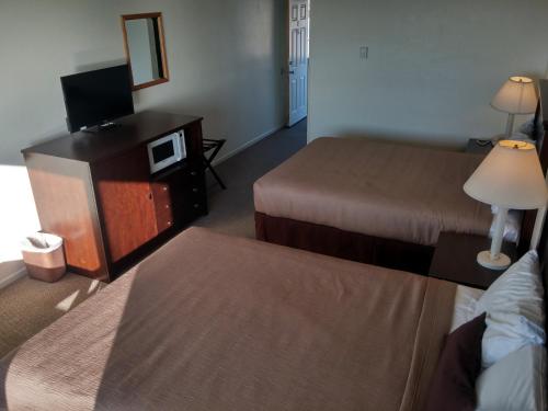 a hotel room with two beds and a television at Silver Sands in Rockaway Beach