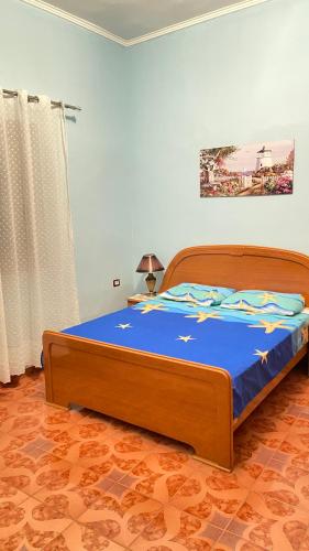 sypialnia z dużym łóżkiem i niebieskim kocem w obiekcie Guest house Luli Strumi w mieście Berat
