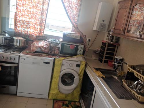 a kitchen with a washing machine and a microwave at Maison de vacances in Ifrane