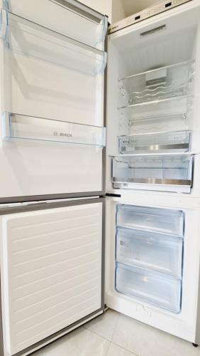 an empty refrigerator with its door open in a kitchen at Le Loft de Village-Neuf - Résidence 4 étoiles in Village-Neuf