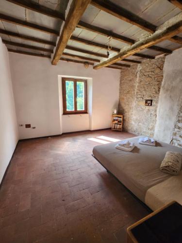 een slaapkamer met een groot bed in een kamer met een raam bij Contea del Piano in Piteglio