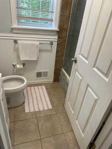 uma casa de banho com um WC, uma janela e uma porta em Fidelia Room B Queen Bed Near EWR Airport and Penn Station em Irvington