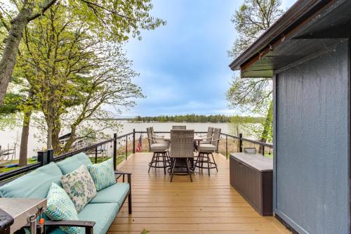 a deck with a couch and a table and chairs at Away at Moose Bay Breezy Point Gem with Game Room in Breezy Point