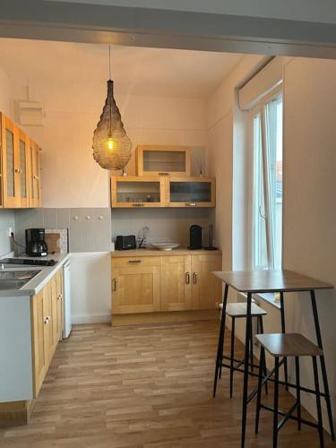 - une cuisine avec une table et deux tabourets dans l'établissement Studio au centre de Wimereux, à Wimereux