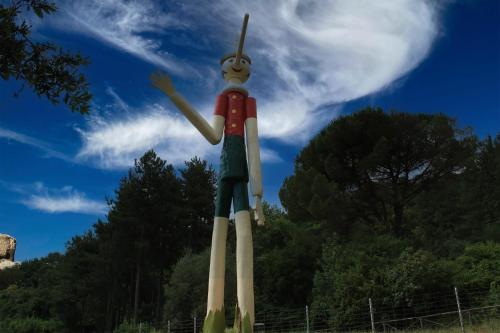 a statue of a man standing on top of a field at Mansarda Pescia in Pescia