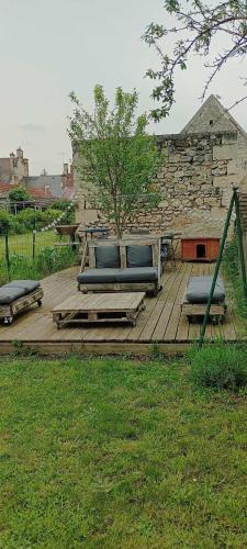 a wooden deck with blue benches and a tree at Chambre chez l’habitant avec entrée et kitchenette privatives in Braine