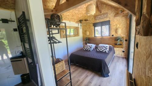 - une chambre avec un lit dans une petite maison dans l'établissement Lodge du Château de Feschaux, à Villeneuve-sous-Pymont