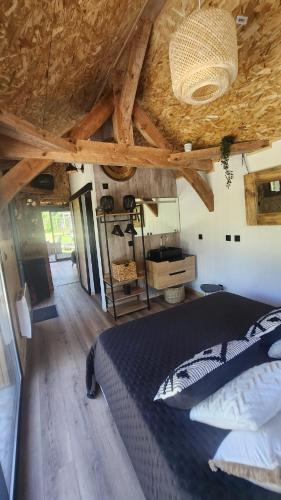 une chambre avec un lit et un plafond en bois dans l'établissement Lodge du Château de Feschaux, à Villeneuve-sous-Pymont