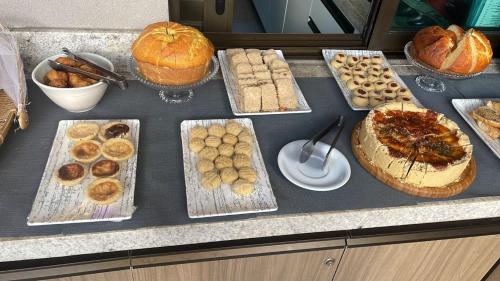 een aanrecht met veel verschillende soorten brood en gebak bij Sunny Hall Acqua com piscina privativa in Porto De Galinhas