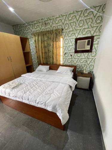 ein Schlafzimmer mit einem großen Bett in einem Zimmer in der Unterkunft Calawazobia Hotel in Uyo