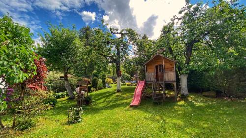 ein Spielhaus in einem Garten mit Rutsche in der Unterkunft Pensjonat Merkury in Świeradów-Zdrój