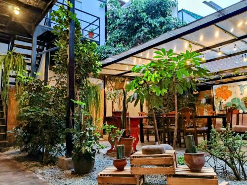 a garden with potted plants and a restaurant at Samanai Wasi Hostel in Lima