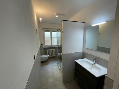 a bathroom with a sink and a toilet and a mirror at A casa di Cato in Merano