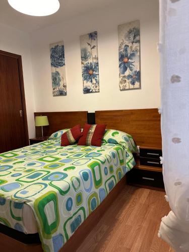 a bedroom with a bed with a colorful comforter at Piso da Ulla in A Estrada