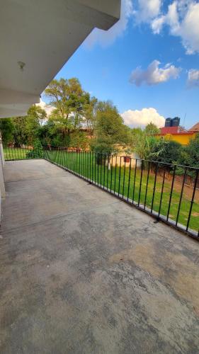 a fence in front of a yard with a park at El Monasterio in San Joaquín