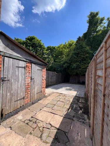 a garage with two doors and a fence at Serene Retreat - Near Bham City Centre & The JQ in Birmingham