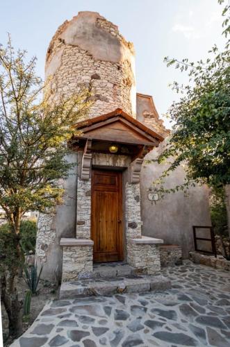 a house with a wooden door and a brick building at Centenario Los Arroyitos in Bernal