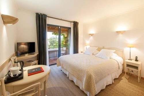a hotel room with a bed and a television at Du Côté Des Olivades in Paradou