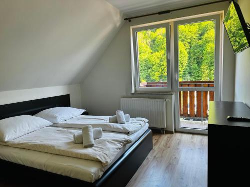 - une chambre avec un lit doté de draps blancs et 2 fenêtres dans l'établissement Nad Grajcarkiem - Pensjonat, à Szczawnica