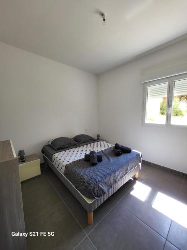 une chambre avec un lit dans une pièce blanche dans l'établissement T2 bord de mer, à Albitreccia