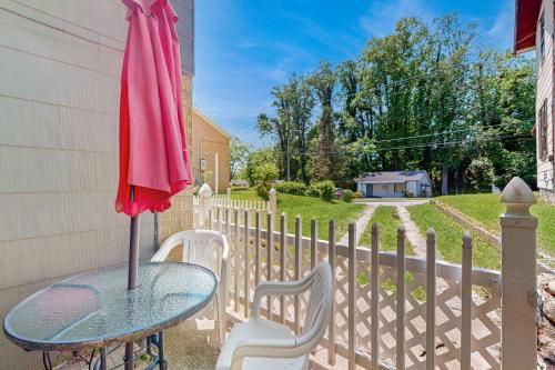 a table and chairs with an umbrella on a fence at Ecusta Dacha in Hendersonville