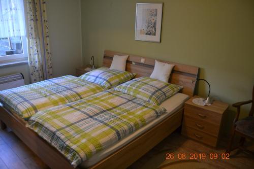 a bedroom with a bed with a plaid comforter at Ferienwohnung Hau in Kradenbach