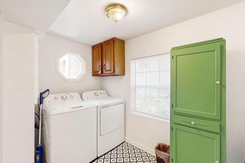 a laundry room with a washer and a green door at Ecusta Dacha in Hendersonville