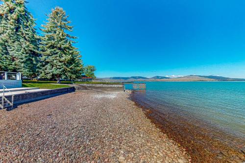 a beach with trees and water on a sunny day at Montana Memory Maker in Polson