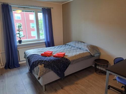 ein Schlafzimmer mit einem Bett mit zwei roten Handtüchern darauf in der Unterkunft Kaski, three-room condo in a prime location, free parking in Tampere