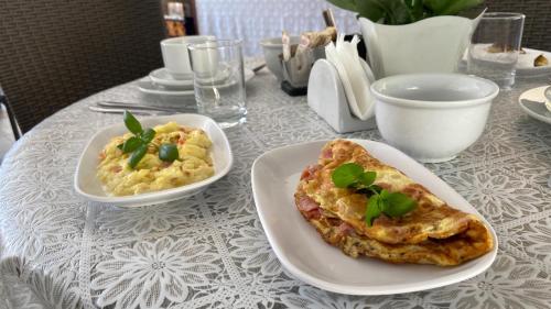 a table with two plates of food on a table at Pousada Pé na Areia Guarujá in Guarujá