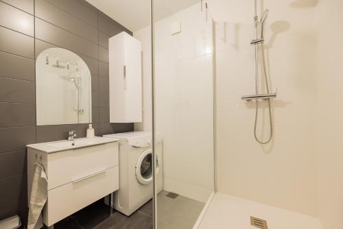 a bathroom with a washing machine and a shower at Gîte de la Louvière - maison de campagne in Grandpré