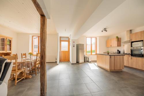 une cuisine et une salle à manger avec une table et une cuisine et une salle à manger dans l'établissement Gîte de la Louvière - maison de campagne, à Grandpré